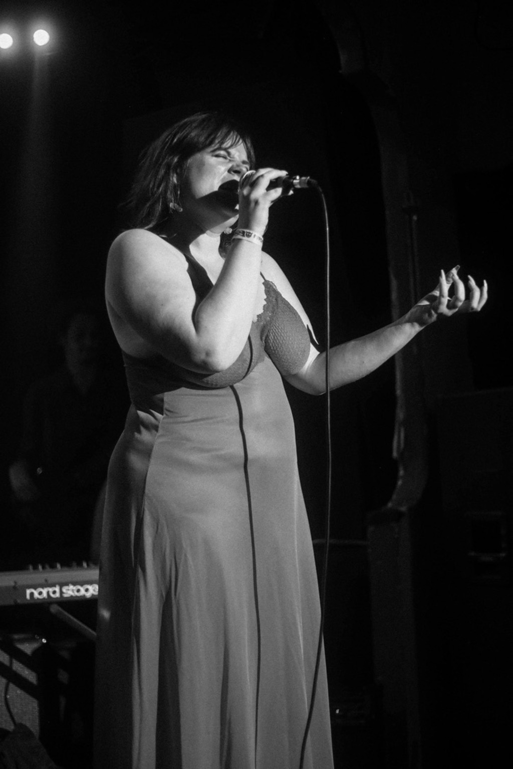 A black and white photograph of Madeline singing, eyes closed.