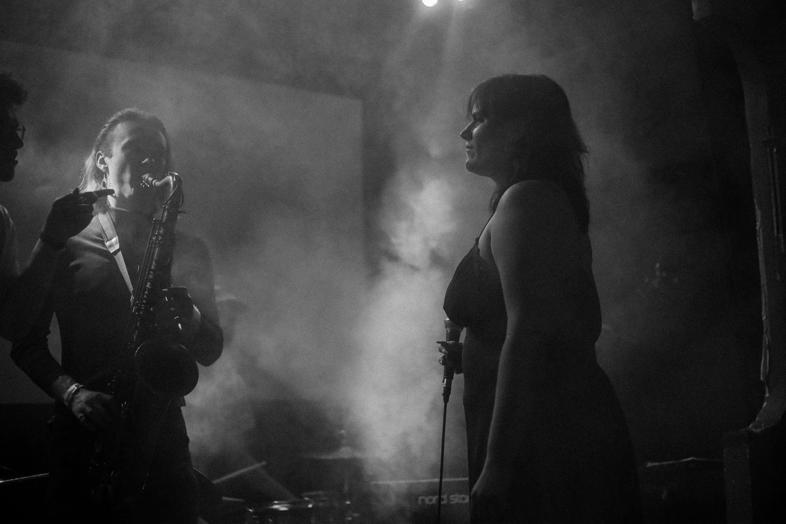 A black and white photograph of Madeline looking back at the band through a fog.